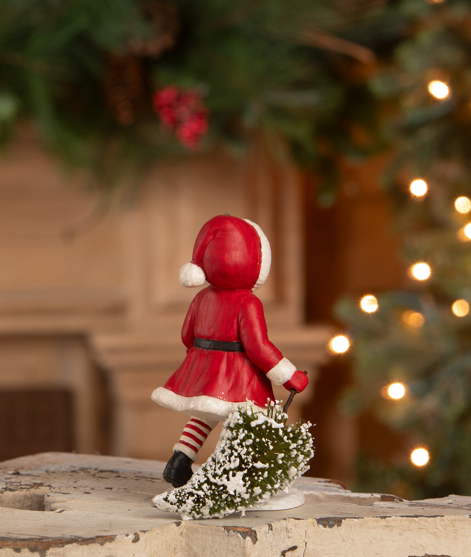 Child in Santa Suit figurine pulling a Christmas tree