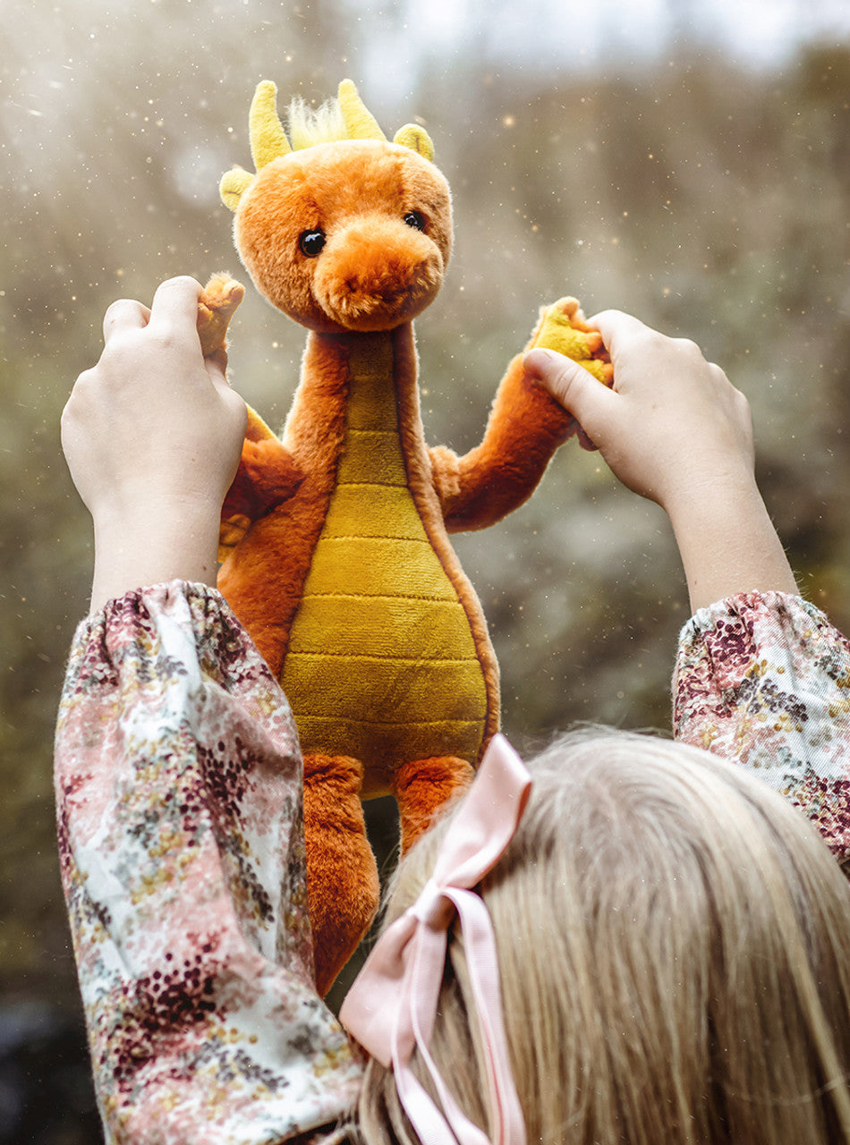 Girl Playing with Diamonds Dragon with Orange and Yellow Plush. by Charlie Bears.
