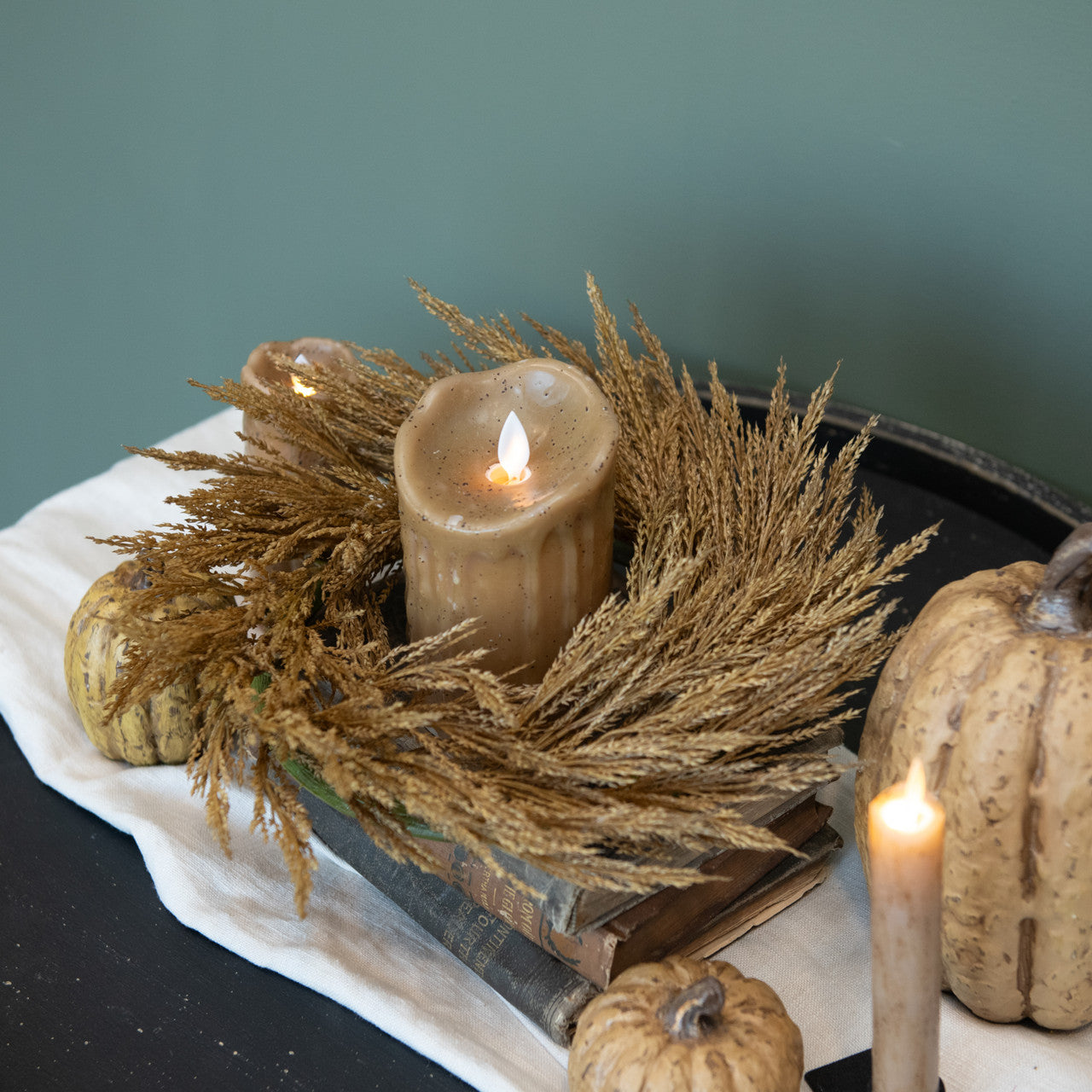 Farmhouse decorating with fake flame, battery-operated candles shown with in a wheat wreath with pumpkins