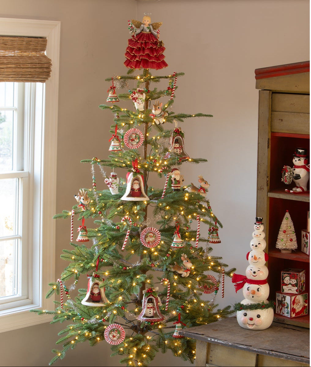 Decorating a Retro Christmas Tree with Bell Ornaments, Santas, Snowmen, Leaping Deer. Frosty Snowman Stack and Retro Christmas Blocks shown on side table.