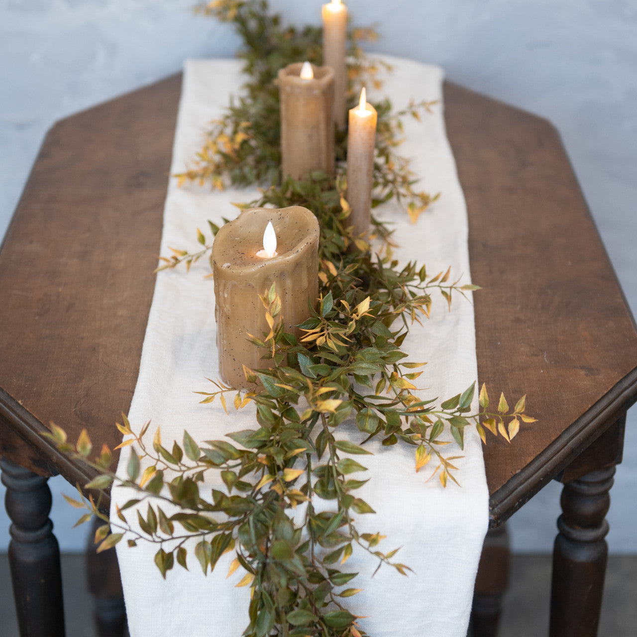 Farmhouse table decorated with fake flame candles for Thanksgiving and fall