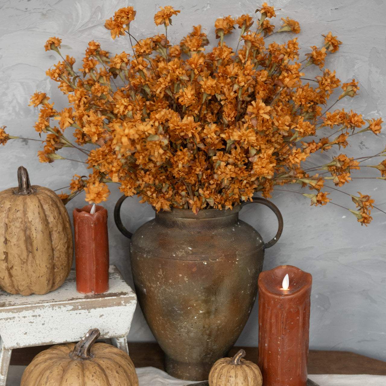 farmhouse decorating for fall with fake flame candles in autumn rust, shown with country pumpkins and floral centerpiece