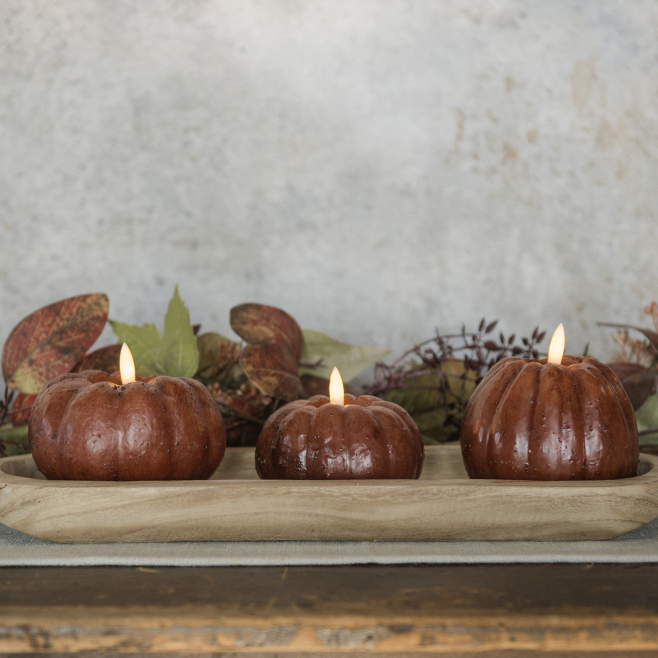 Flameless Pumpkin Candles, battery-operated. Shown in Ginger Brown color wax in 3 assorted sizes and shapes, shown in a fall tablescape.