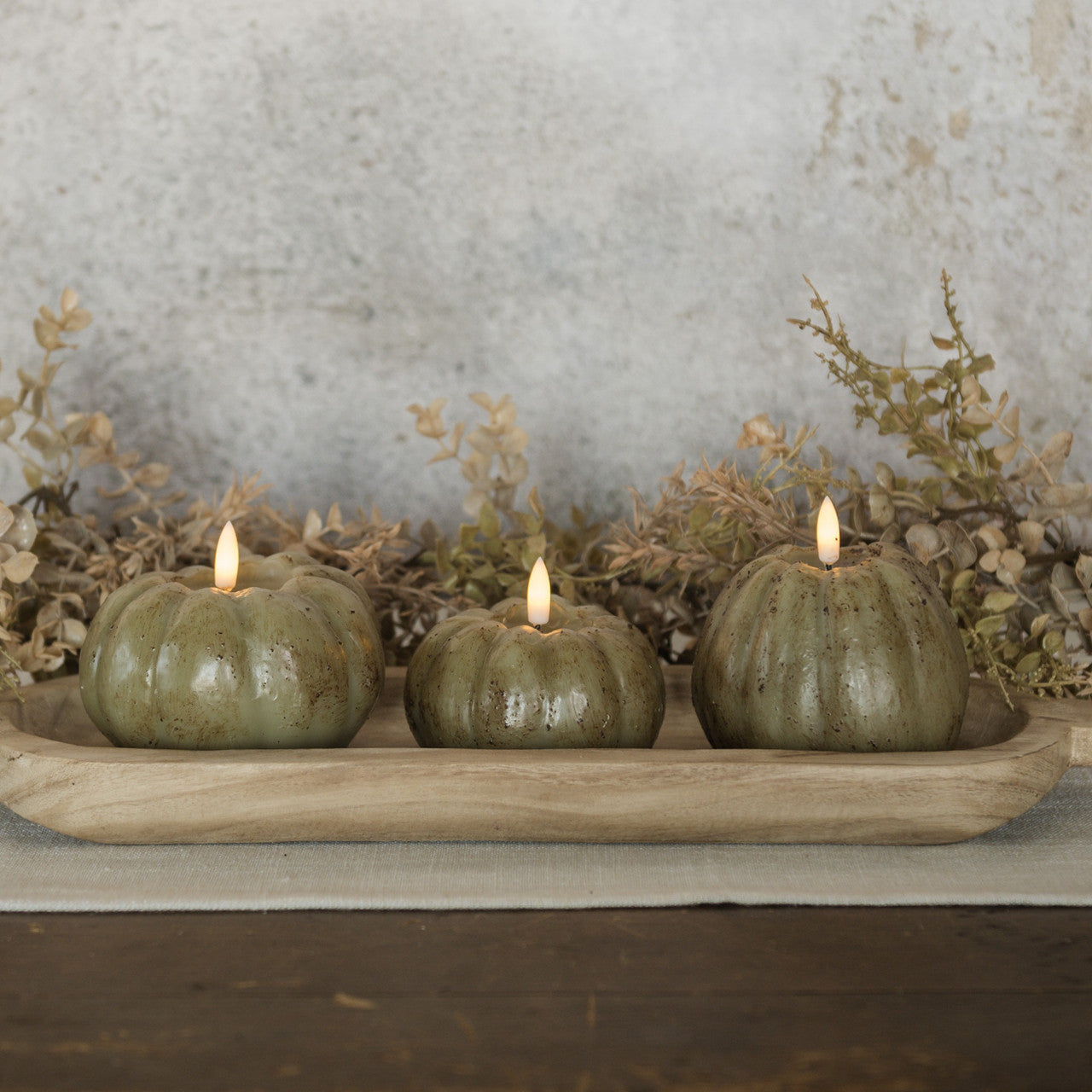 Set of 3 green Flameless Pumpkin Candles shown decorating a table for fall.