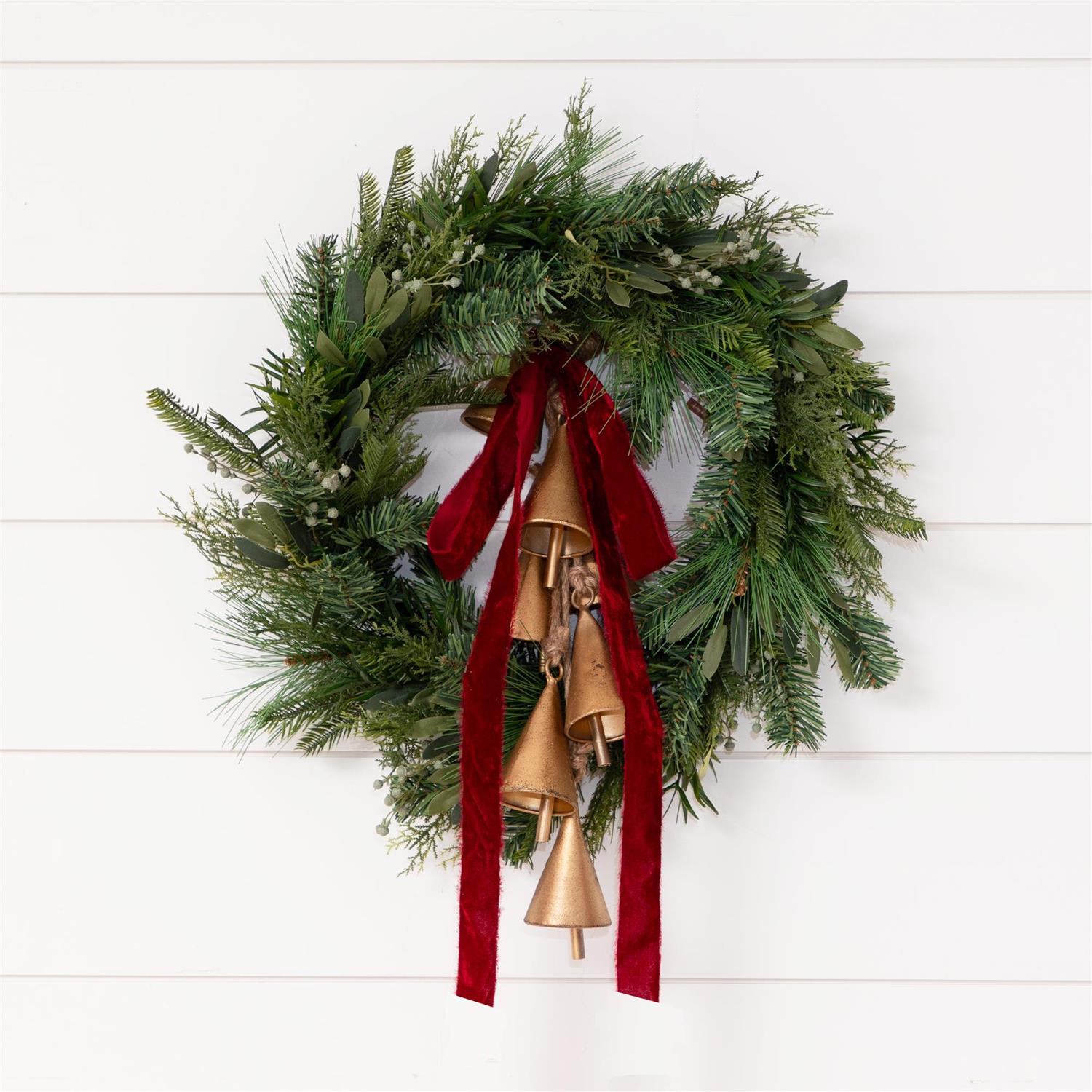 Red Raw Edge Velvet Ribbon shown tied in a bow on a wreath with bells