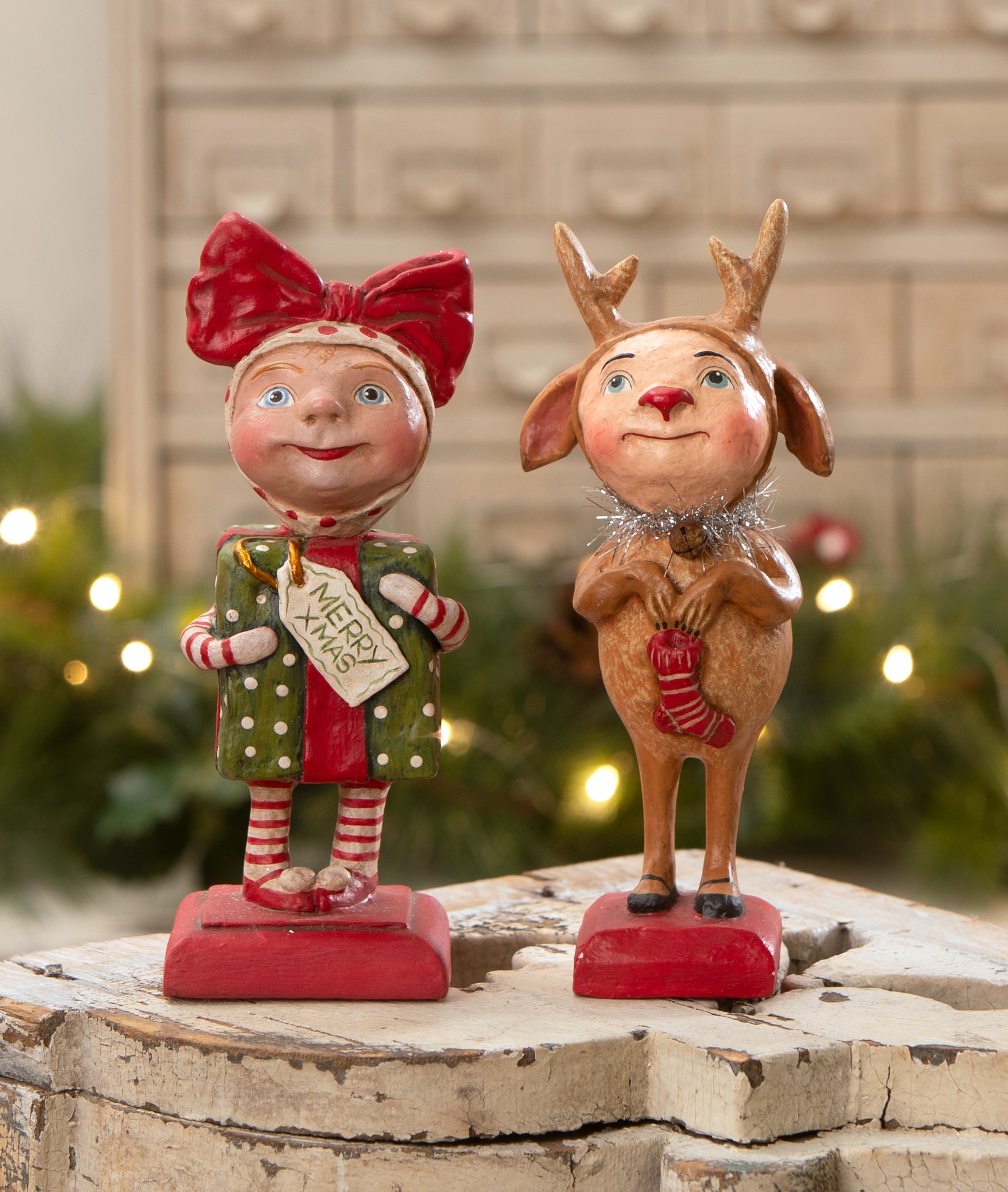 Two cute Christmas figurines, Surprise Package girl (dressed up as a Christmas gift) and Reindeer Boy dressed up as Rudolph the red nosed reindeer.