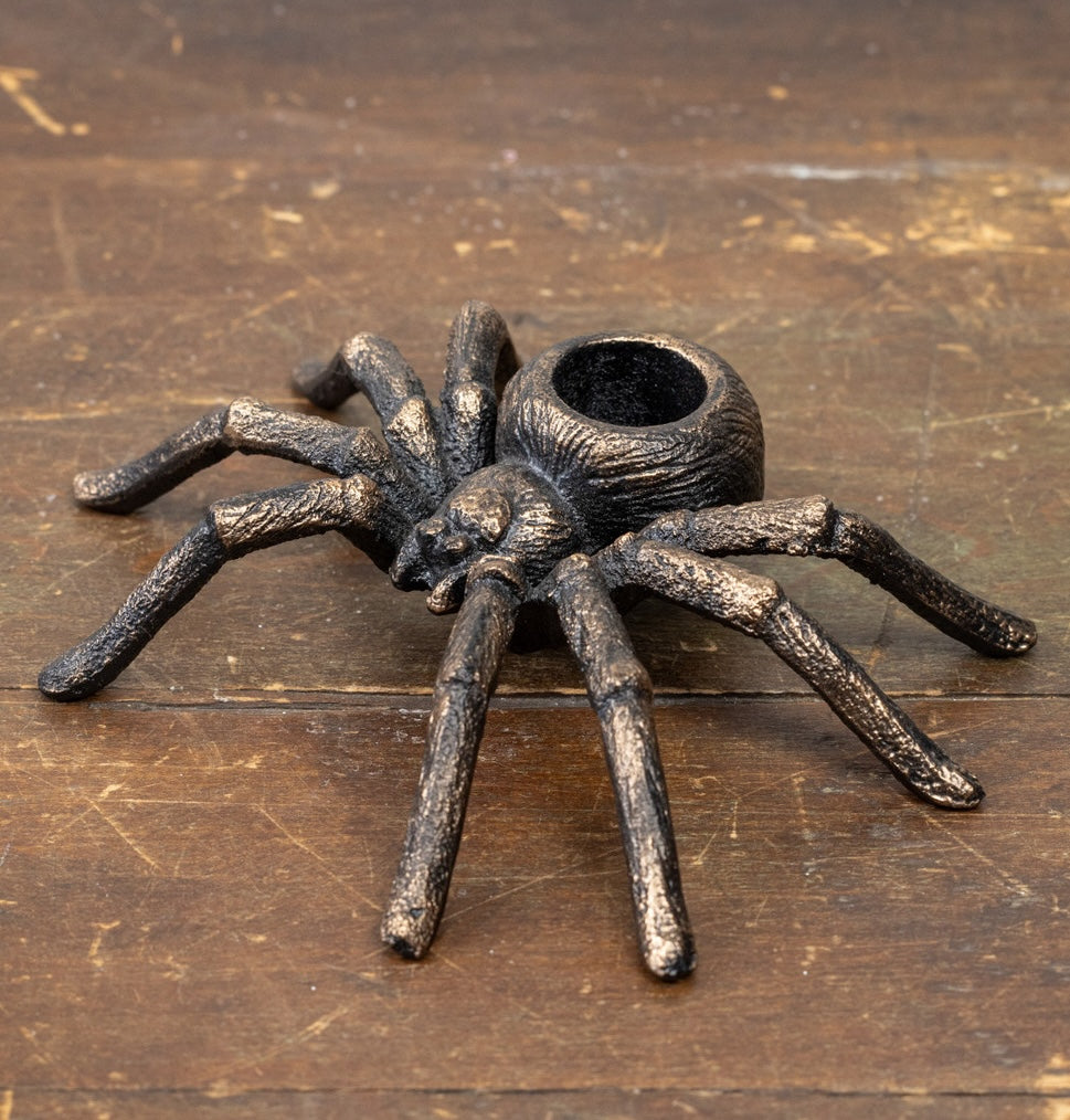 Gold spider candle holder shown on a table