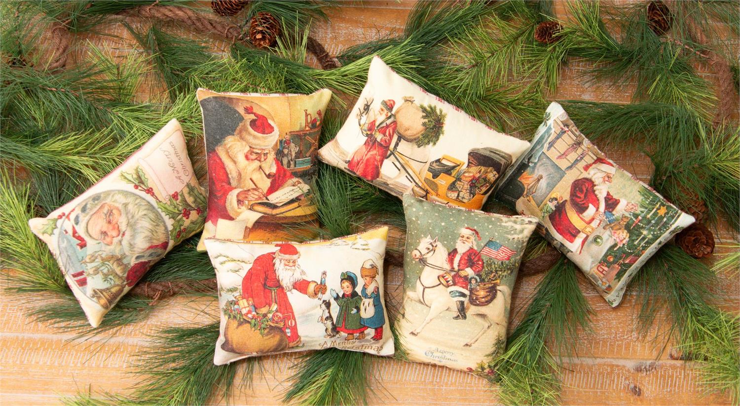 Vintage Christmas Postcard Pillows with images of Santa Claus shown on a table of greens